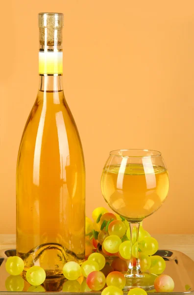 Białe wino w szkle z butelki na taca na beżowym tle — Zdjęcie stockowe