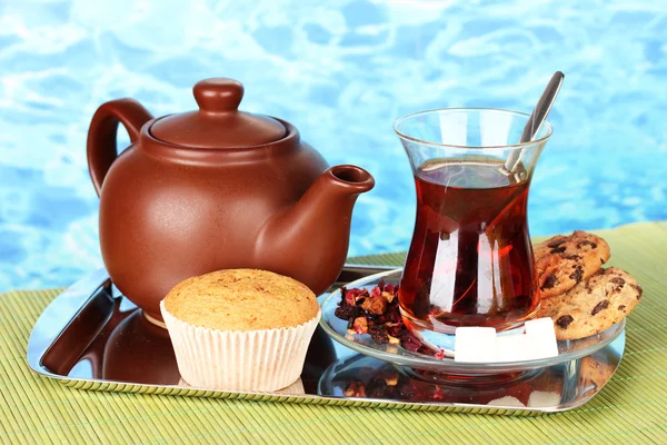 Glass of Turkish tea and kettle on color background — Stock Photo, Image