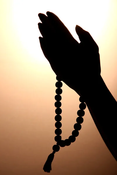 Female hands with rosary, on brown background — Stock Photo, Image