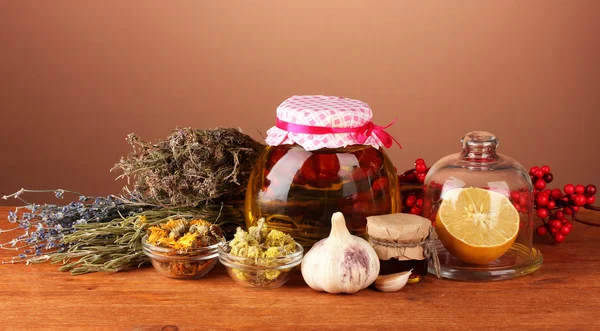 Miel y otras medicinas naturales para la salida de invierno, sobre mesa de madera sobre fondo marrón — Foto de Stock