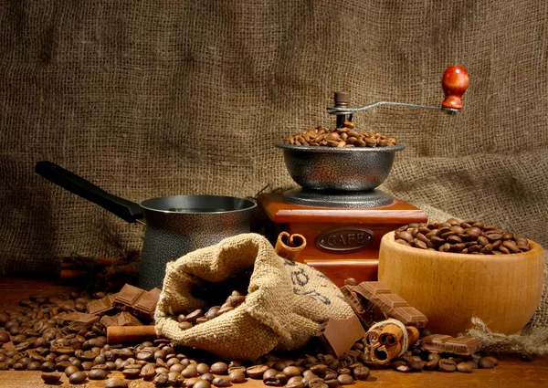 Coffee grinder, turk and cup of coffee on burlap background — Stock Photo, Image