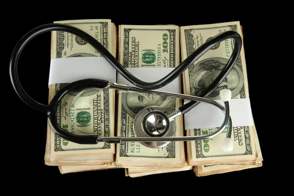 Concetto di costo sanitario: stetoscopio e dollari isolati su nero Foto Stock Royalty Free