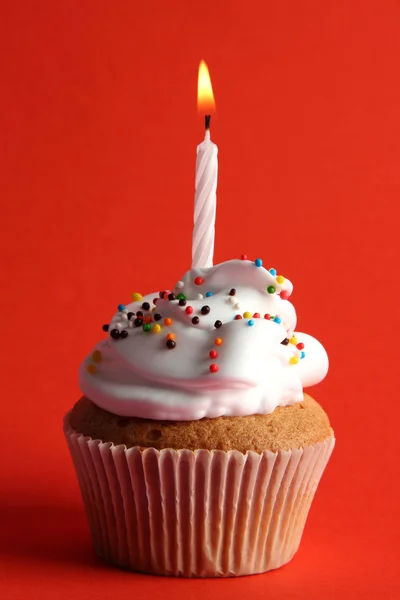 Bolo de aniversário saboroso com vela, no fundo vermelho — Fotografia de Stock