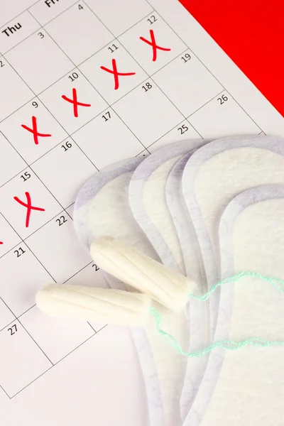 Calendário de menstruação com absorventes e tampões sanitários, close-up — Fotografia de Stock