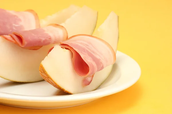 Jambon et melon de parme, sur fond jaune — Photo