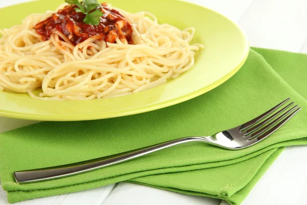 Italian spaghetti in plate on wooden table — Stock Photo, Image