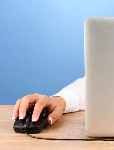 女人的手推键的电脑鼠标，在蓝色背景特写 — 图库照片