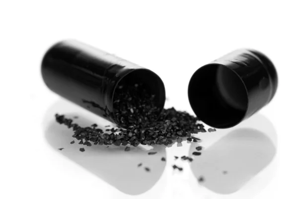 Activated carbon in capsule isolated on white — Stock Photo, Image