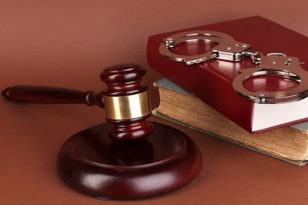 Gavel, handcuffs and book on law on brown background — Stock Photo, Image