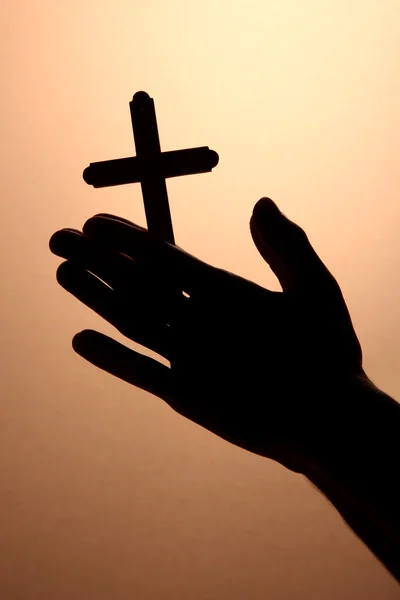 Männerhände mit Kruzifix, auf braunem Hintergrund — Stockfoto