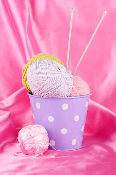 Kleur emmer met veelkleurige ballen van loopvlak op kleur weefsel achtergrond — Stockfoto