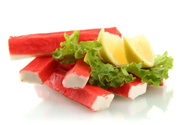 Palitos de cangrejo sobre hojas de lechuga con limón, aislados sobre blanco — Foto de Stock