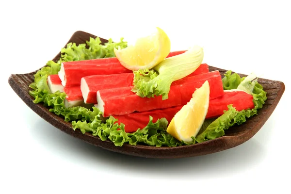 Krabí tyčinky s listy salátu a citron na desce izolovaných na bílém — Stock fotografie