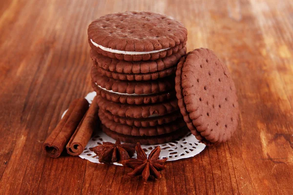 Chocolate cookies with creamy layer on wooden table close-up — Stock Photo, Image