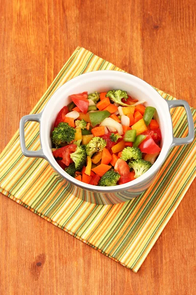 Ragoût de légumes en pot gris sur serviette de couleur sur fond en bois — Photo