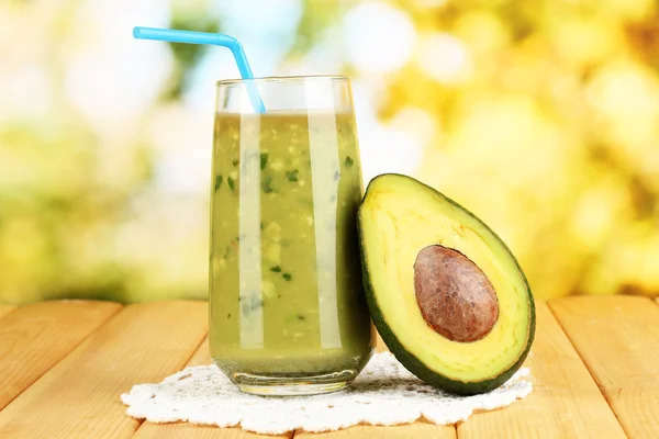 Useful fresh avocado and half avocado on wooden table on natural background — Stock Photo, Image