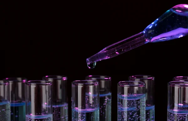 Test-tubes with liquid on black background — Stock Photo, Image