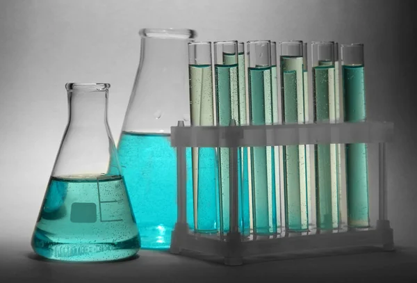 灰色の背景に青い液体試験管 — ストック写真