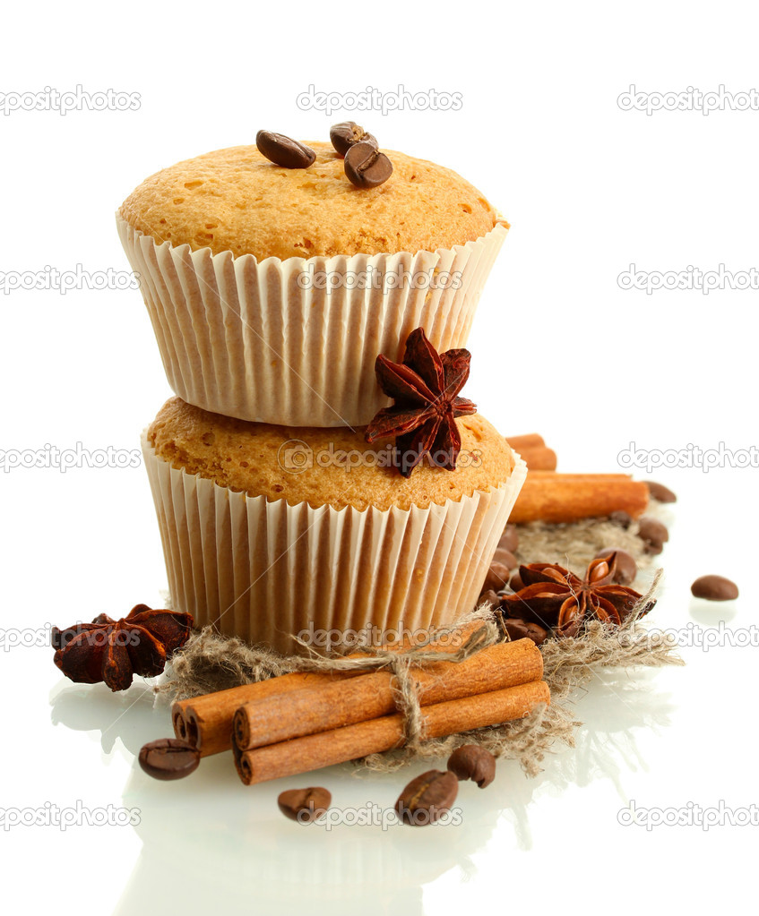 tasty muffin cakes on burlap, spices and coffee seeds, isolated on white