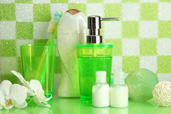 Bath accessories on shelf in bathroom on green tile wall background — Stock Photo, Image