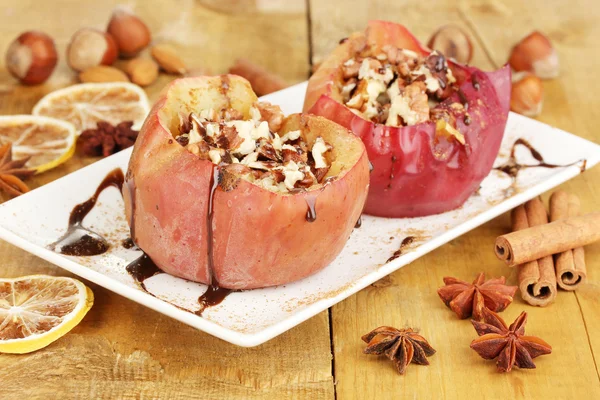 Baked apples on plate on wooden table — Stock Photo, Image