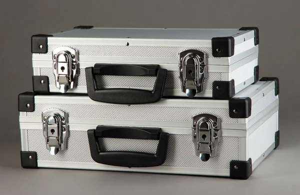 Silberne Koffer auf grauem Hintergrund — Stockfoto