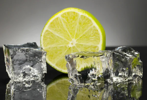 Ice cubes with lime on black background — Stock Photo, Image