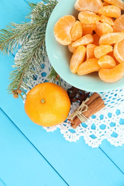 Tasty mandarine's slices on color plate on blue background — Stock Photo, Image