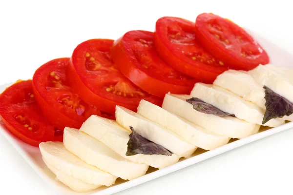Gustosa mozzarella con pomodori su piatto isolato su bianco — Foto Stock