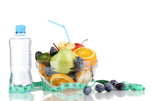 Стеклянная чаша с фруктами для диеты, измерительная лента и бутылка воды изолированы на белом — стоковое фото