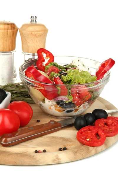 Ensalada griega fresca en tazón de vidrio rodeado de ingredientes para cocinar aislado en blanco — Foto de Stock