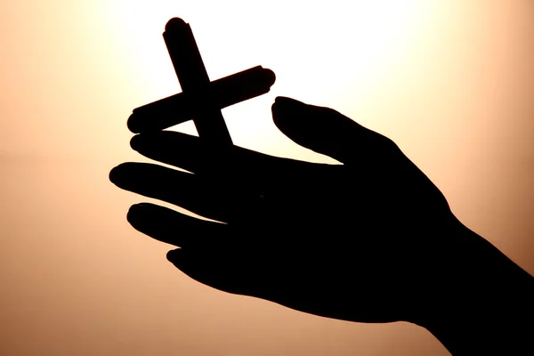 Mãos femininas com crucifixo, no fundo marrom — Fotografia de Stock