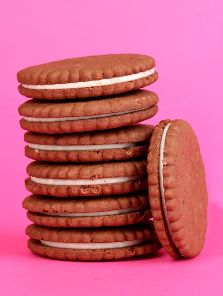 Schokoladenkekse mit cremiger Schicht auf rosa Hintergrund — Stockfoto
