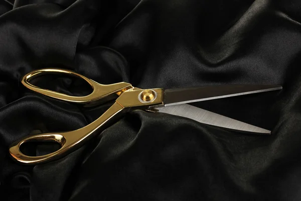 Metal scissors on black fabric — Stock Photo, Image