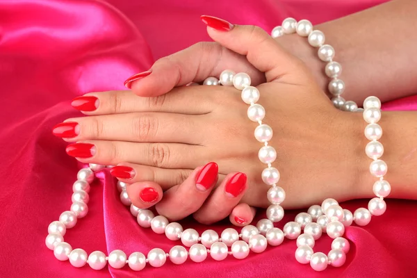 Female hands holding beads on color background Stock Image