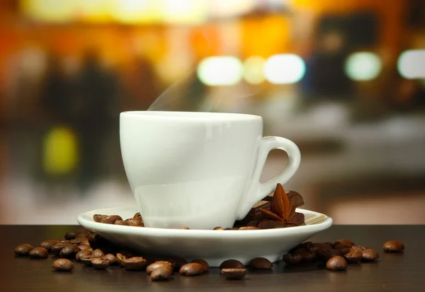 Kopje koffie met bonen op tafel in café — Stockfoto