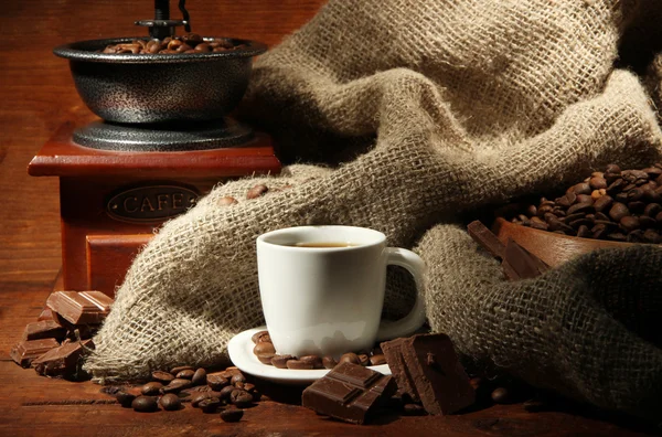 Kávékarcoló és csésze kávé barna fa háttér — Stock Fotó