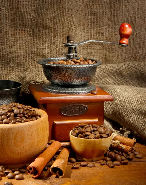 Koffiemolen en kopje koffie op jute achtergrond — Stockfoto