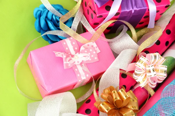 Rotoli di carta da regalo di Natale con nastri, fiocchi su sfondo a colori — Foto Stock