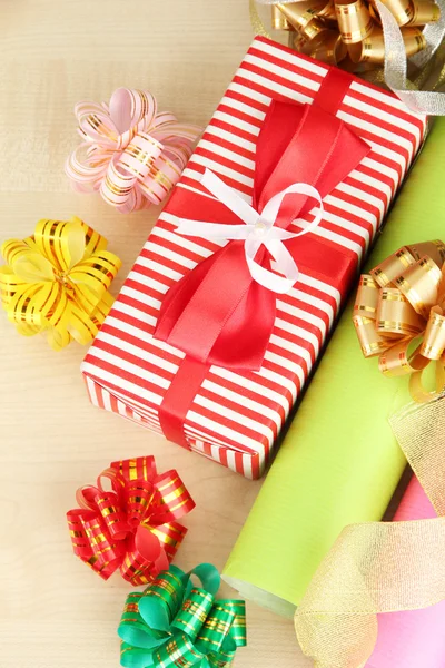 Rouleaux de papier d'emballage de Noël avec rubans, noeuds sur fond en bois — Photo