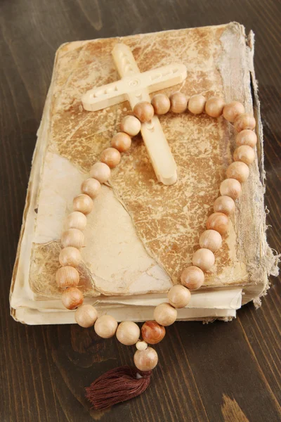 Bible, rosary and cross on wooden table close-up — Stock Photo, Image