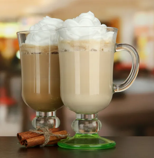 Latte de café perfumado em copos copos com vagens de baunilha, na mesa no café — Fotografia de Stock