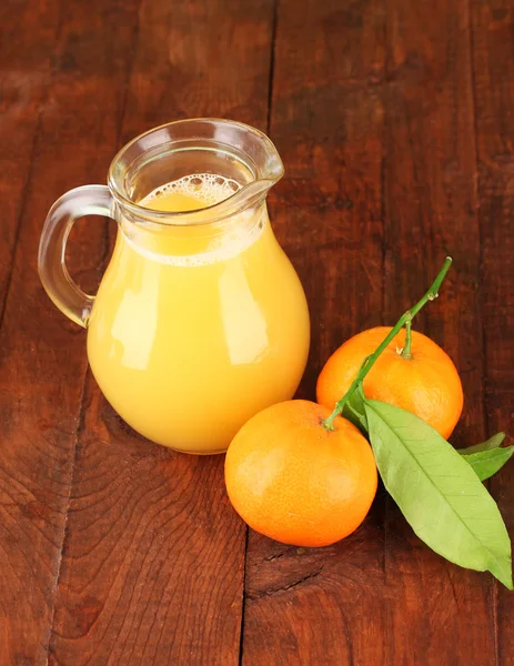 Cruche pleine de jus d'orange, sur fond en bois — Photo