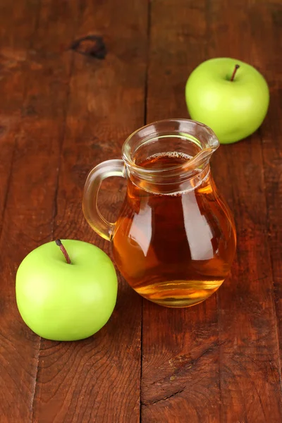 Full kannan av äppeljuice och äpple på trä bakgrund — Stockfoto