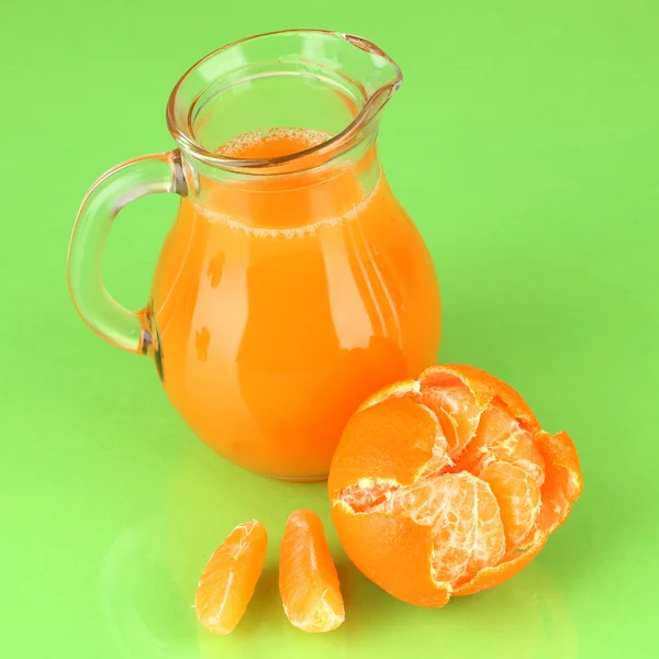 Jarra llena de jugo de mandarina, sobre fondo de color madera —  Fotos de Stock