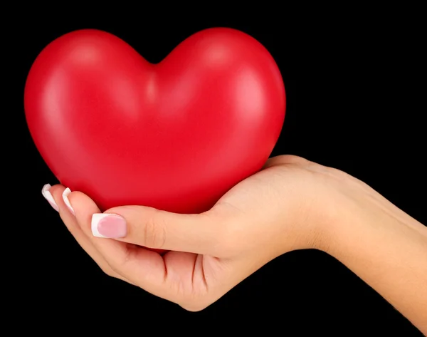 Red heart in woman's hand, on black background close-up — Stock Photo, Image