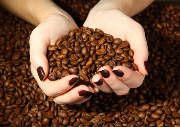 Manos femeninas con granos de café, de cerca — Foto de Stock
