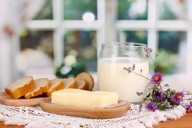 Ahşap kutusunda ekmek ve süt penceresi arka planda çevrili tereyağı