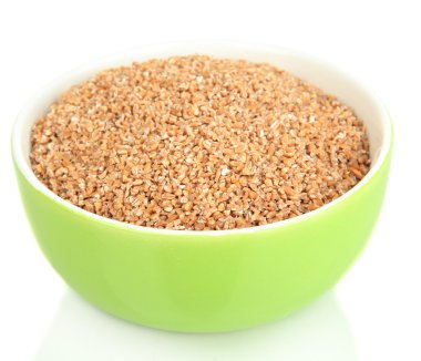 Yeşil kase üzerinde beyaz izole buğday kepeği dolu