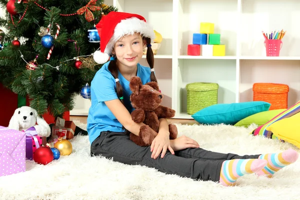 크리스마스 트리 근처에 앉아 어린 소녀 — 스톡 사진